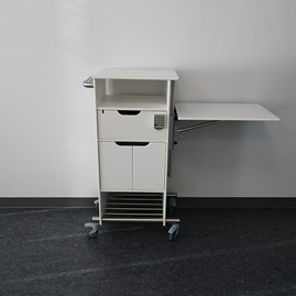 Swing360 er et hospital sidebord med justerbar bordplade.